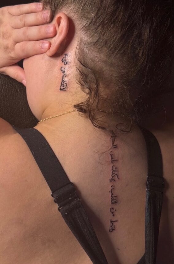 Arabic script behind the ear and a longer line of it running down the upper spine