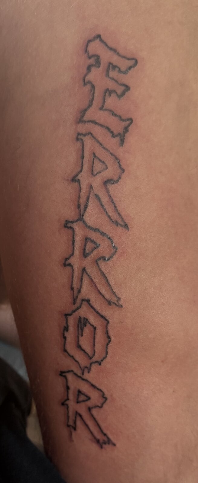 The word ERROR stacked vertically in jagged outlined letters down the back of an arm