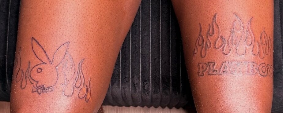 A bunny head wrapped in flames above one knee and flaming outlined lettering above the other