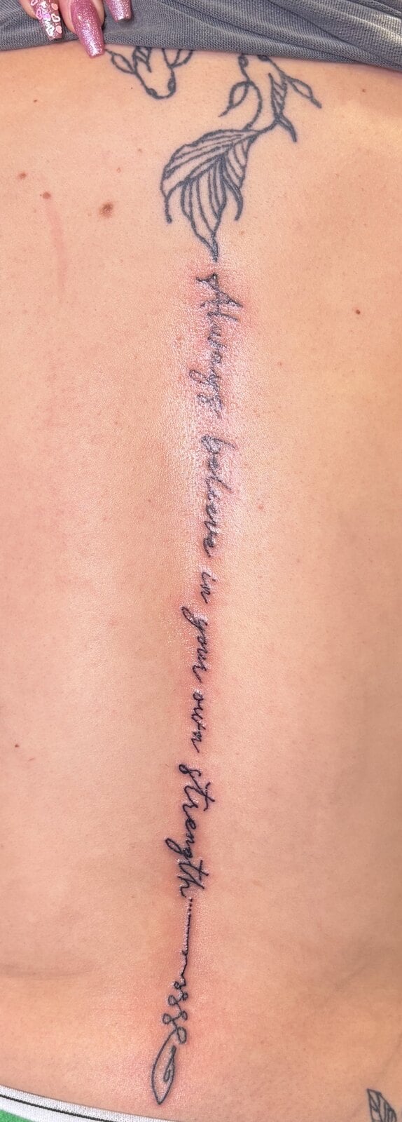 A line of fine script running the full length of the spine, ending in a small arrow