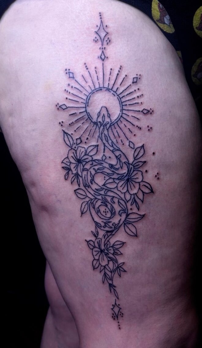 A snake winding down through flowers beneath a radiating sunburst, in fine black linework