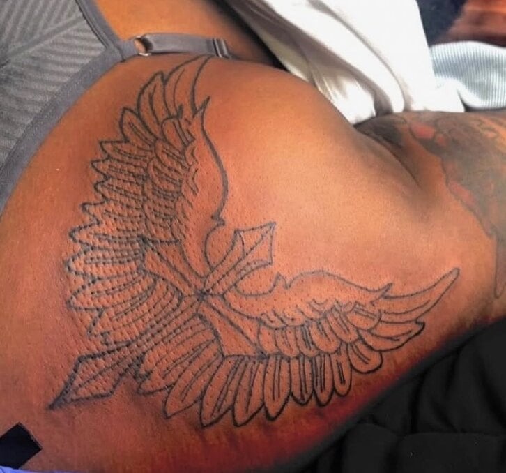A cross with wide feathered wings in fine black linework